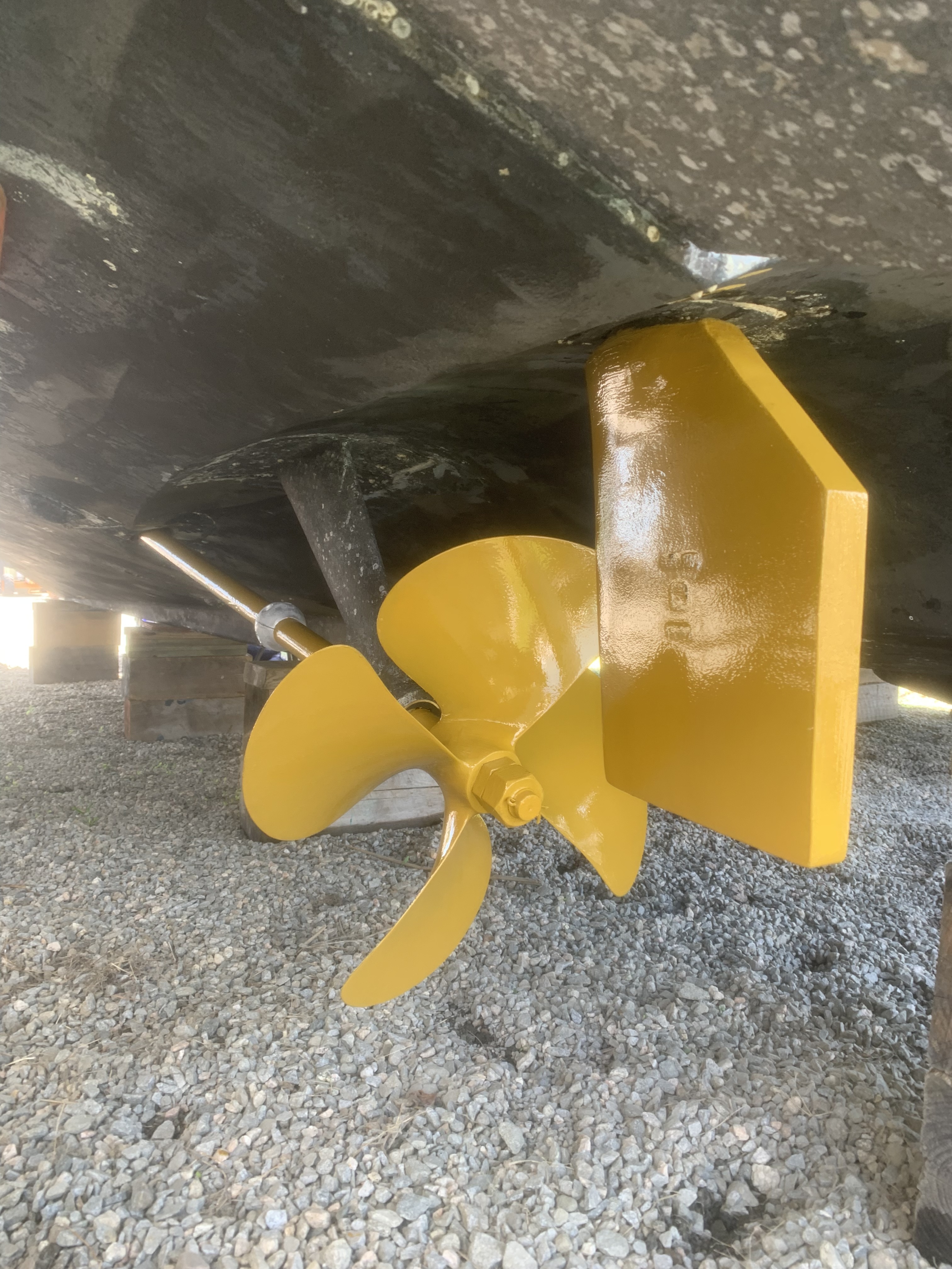 Running gear after — fresh yellow painted prop and skeg